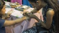 Artist applying henna tattoo on child hand