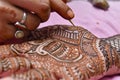 Artist applying henna tattoo on women hand.Close up shot of traditional Indian decorative art mehandi Royalty Free Stock Photo