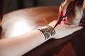 Artist applying henna tattoo on women hands. Mehndi is traditional Indian decorative art. Royalty Free Stock Photo