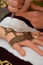 Artist applying henna tattoo on women hands. Mehndi is traditional moroccan decorative art. Royalty Free Stock Photo