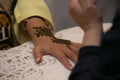 Artist applying henna tattoo on women hands. Mehndi is traditional moroccan decorative art. Close-up, Royalty Free Stock Photo