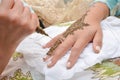 Artist applying henna tattoo on women hands. Mehndi is traditional moroccan decorative art. Royalty Free Stock Photo