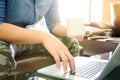 artist asian man holding coffee cup drinking coffee and use laptop search new knowledge play social media