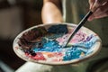 artist brush mix color painting on palette is holding in his hand closeup Royalty Free Stock Photo