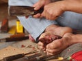 Artist carving wooden BUDDHA figure with primitive self-made tools and small hammer