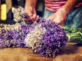 Artist creating lavander bunch. Wooden table with lavender