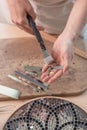 Artist cutting sheets of stained glass into small mosaic squares. Close-up