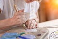 Artist cutting sheets of stained glass into small mosaic squares. Close-up