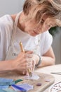 Artist cutting sheets of stained glass into small mosaic squares. Close-up