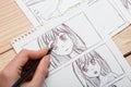 Artist drawing an anime comic book in a studio