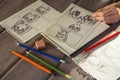 Artist drawing an anime comic book in a studio. Wooden desk, natural light