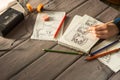 Artist drawing an anime comic book in a studio. Wooden desk, natural light. Creativity and inspiration concept Royalty Free Stock Photo