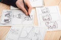 Artist drawing an anime comic book in a studio. Wooden desk, natural light. Creativity and inspiration concept Royalty Free Stock Photo
