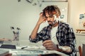 Artist with dreadlocks feeling concerned having too much work