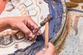 An artist engraving pattern on the tray, street workshop. Close-up. Samarkand, Uzbekistan