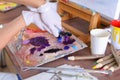 Artist extrudes paint from tubes on palette for mixing colors t Royalty Free Stock Photo