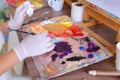 Artist extrudes paint from tubes on palette for mixing colors t Royalty Free Stock Photo