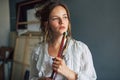 An artist female holding a pinch of brushes in her art studio. A young woman student painter searching for imagination at home Royalty Free Stock Photo