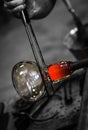 Artist glass blower working glass paste on his workbench. A glass crafter is burning and blowing an art piece