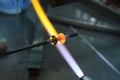 Artist of glass at work. Hand made glass beads in the fire out of red hot glowing glass for pandora bracelets,focus glass bead aro Royalty Free Stock Photo
