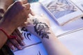 Artist grafting temporary henna mehendi tattoo art onto hand fin Royalty Free Stock Photo