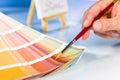 Artist hand pointing to color samples in palette with paintbrush Royalty Free Stock Photo