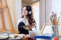 Artist in headphones paints picture on canvas Royalty Free Stock Photo