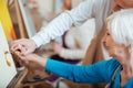 Artist helping his elderly colleague in painting class Royalty Free Stock Photo