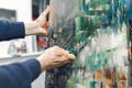 Artist with a knife palette in his hands draws a picture.Artist`s hand with a knife palette paints on the canvas and a place for Royalty Free Stock Photo