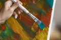 Artist makes brush strokes on canvas painting, close up Royalty Free Stock Photo