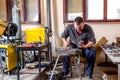 Artist is making figure by welding few metal wires in his workshop, barehanded