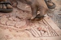 Artist making handmade design on red stone for temple