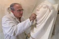 Artist master at work in studio on a sculpture of face Royalty Free Stock Photo