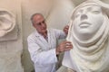 Artist master at work in studio on a sculpture of face Royalty Free Stock Photo