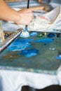 Artist mixes oil paints on pallet Royalty Free Stock Photo