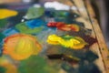 Artist mixes oil paints on pallet with various Royalty Free Stock Photo