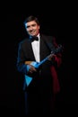 Artist musician, a dark-haired man in a black suit and a bow tie, plays a balalaika Royalty Free Stock Photo