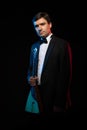 Artist musician, a dark-haired man in a black suit and a bow tie, plays a balalaika Royalty Free Stock Photo