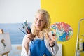 Artist with paint brushes and color palette in her hands Royalty Free Stock Photo