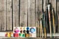 Artist paint brushes and palette on wooden background. Royalty Free Stock Photo