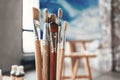 Artist paintbrushes closeup on blurred background of painter workshop. Different brushes in drawing studio interior