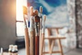 Artist paintbrushes closeup on blurred background of painter workshop. Different brushes in drawing studio interior.