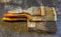 Three oversized used paintbrushes stacked on top of each other. Royalty Free Stock Photo