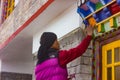 Artist painting Buddhist symbols on window in a Monastery in Sikkim, India