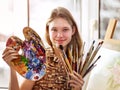 Artist painting on easel in studio. Girl paints with brush. Royalty Free Stock Photo