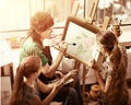 Artist painting easel in studio. Authentic grandmother and kids. Royalty Free Stock Photo