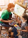 Artist painting easel in studio. Authentic grandmother and kids. Royalty Free Stock Photo