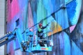 Artist painting mural on building in Sacramento