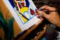 An artist painting a Queen of Hearts playing card on a canvas in their studio Royalty Free Stock Photo