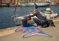 Artist paints bollard on Port du Bassin de la Marine, Dunkerque, France